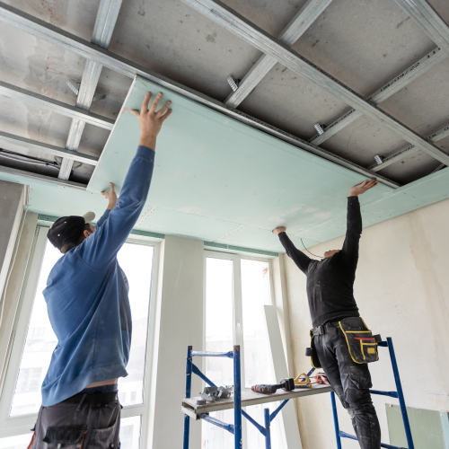 Two men installing drywall
